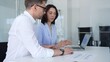 © rogerphoto - Business professionals collaborating on a data analysis project, discussing financial charts and market strategy together in a modern office, analyzing performance on laptop