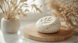© Iqra - Natural skincare stone with botanical leaf imprint on wooden stand, evoking organic beauty and wellness.