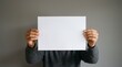 © Iqra - Person holding blank white paper in front of face, conveying mystery and space for text