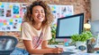 © NovaVision - A happy woman with curly hair works at her creative office desk, smiling.