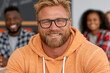 © Juan - Smiling man with glasses in classroom or group learning environment