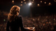 © Miftakhul - Female speaker at podium facing large audience, dramatic backlighting with bokeh stage lights, business attire, concept for corporate presentations, public speaking and leadership events
