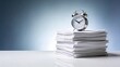 © Husen - An alarm clock sits on top of a stack of papers on a desk.