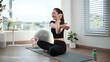 © wattana - Young woman stretching her arm across the chest during a home workout. Healthy lifestyle concept.