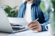 © LAONG - Business professional reviewing financial documents and calculating expenses on laptop with calculator at desk, personal finance management, accounting analysis and budget planning in modern workspace