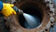 © miss irine - Worker uses high pressure water jet to clean clogged sewer pipe. Plumber clears blockage with hose in dirty drain. Sewage maintenance service for underground utility system.