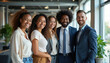 © miss irine - Diverse group of smiling business people stand in modern office near large window. Teamwork and success visible in happy co-workers posing together in pro workspace.