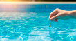 © Irina Kado - Person testing pool water with chemical test strip to check pH and chlorine levels. This maintenance activity is used for home pool care, water quality safety, and residential sanitation.