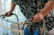 © amnaj - Senior woman carefully walking with a medical walker, receiving support and assistance for her aging and rehabilitation needs