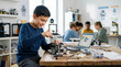 © Xenia - Smiling boy building a robot and learning to code on a laptop in a classroom. Elementary student assembling electronic hardware for a STEM school project. Technology and engineering education