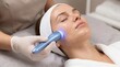 © H & F - Cosmetologist performing cryotherapy facial on female client using cold treatment device for skin tightening and glow.