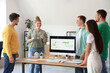 © Pixel-Shot - Colleagues with wind turbine model having business meeting in office. Green energy concept