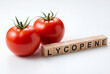 © Meow Creations - Two fresh red tomatoes with wooden blocks spelling lycopene, a healthy antioxidant nutrient