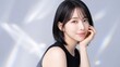 © YT - やわらかな微笑みを浮かべて頬杖をつく若い女性のビューティーポートレート。黒のノースリーブトップスとショートボブヘアが映える、透明感のある肌と洗練された表情を引き立てた、スキンケア、コスメ、美容医療、ヘアケア、ライフスタイル、女性向け広告やブランドビジュアルに使いやすい高解像度イメージ素材