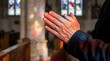 © Whisnu - Christian Prayer Hands Illuminated by Stained Glass in Soft Focus Church Background
