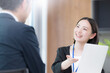 © kapinon - 綺麗なオフィスで法人営業でヒアリングしながら提案(プレゼン)する若い女性社員のポートレート信頼と商談　保険や企画の提案などのイメージ