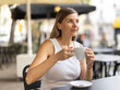 © JackF - On summer outside of cafe, woman is relaxing at table, drinking coffee. Sphere of catering and entertainment for comfort of inhabitants of metropolis