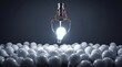 © Ohana - 3D claw machine capturing glowing light bulb among pile of dim bulbs in factory