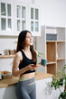 © Nuttapong punna - Fit woman using smartphone in healthy kitchen, fitness and nutrition lifestyle, meal planning, workout routine, clean eating, wellness