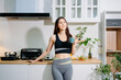 © Nuttapong punna - Fit woman using smartphone in healthy kitchen, fitness and nutrition lifestyle, meal planning, workout routine, clean eating, wellness