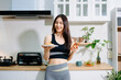 © Nuttapong punna - Fit woman using smartphone in healthy kitchen, fitness and nutrition lifestyle, meal planning, workout routine, clean eating, wellness