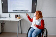 © Halfpoint - Female student in wheelchair presenting her project in front of classroom.