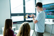 © Halfpoint - Teen boy presenting robotic project in front of classroom.