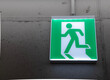© Yulia - Emergency exit button with green light on concrete wall. Minimal industrial interior with copy space, safety and evacuation concept.