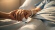 © Z Style - Nurse holding elderly patient's hand in hospital bed, showing compassion and care.