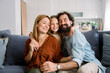 © Westend61 - Family hugging and smiling together in living room at home