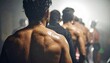 © ruangrit19 - Back view of a focused group of athletic men training together in a dark gym environment under dramatic spotlighting for fitness motivation.