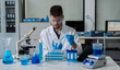 © NINENII - Lab work, Doctor holds a test tube takes the test from a test tube in analysis, blood, DNA, test tube stand.