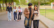 © Raushan_films - Indian young adult gen z busy boy girl use tab look screen talk share new online e learning study plan place. pupil female male man group speak funny gossip enjoy break day have fun joy park