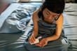 © Davor - Young woman taking pills in bed at home
