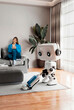 © Rendara Studio - 3D home robot vacuum while woman relaxes in modern living room