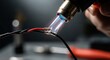 © Hungarian - Technician uses a heat gun to shrink insulating tubing onto electrical wire connections.