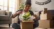 © ipman - Happy woman unpacking a houseplant in a cardboard box after moving home