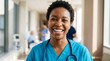© Phatharaporn - A cheerful healthcare professional wearing scrubs smiles warmly at the camera, embodying positivity in a medical environment