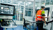 © ultramansk - Three engineers program an industrial robot or 5-axis CNC machine using an AI interface. The team manufactures advanced microchips or high-tech components in a smart factory.