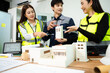 © Nuttapong punna - Engineer teams meeting working together wear worker helmets hardhat on construction site