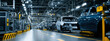 © sam richter - Automated vehicle assembly line inside a modern brightly lit industrial factory manufacturing car frames along conveyor belts