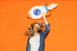 © VISTA by Westend61 - Female entrepreneur jumping with handmade paper rocket for success
