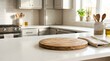 © Svitlana - Empty kitchen counter with round wooden cutting board with copy space for product placement and blurred modern bright kitchen interior, mockup for kitchen brands, home decor, food packaging and