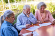 © Robert Kneschke - Senior Adults Doing Cognitive Exercises Outdoors At Rehab Center For Brain Injury Recovery And Mental Health Focus And Concentration On Table