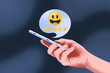 © hunzra - Hand holding smartphone with smiling face rating and five stars, feedback and review concept for app and website
