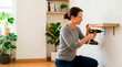 © Xenia - Smiling woman wearing safety glasses using a power drill to install a wooden shelf. Happy female doing DIY home improvement and carpentry work in a bright room