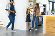 © Wavebreak Media - Family walking in home kitchen, man holding yellow tape measure, child wearing wheeled sneakers
