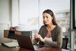 © gzorgz - Confdient businesswoman wearing business casual and and using laptop in a modern bright office
