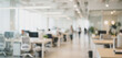 © Vhagar - A modern office environment with desks and computers, featuring blurred figures of employees working, showcasing a collaborative workspace.