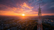 © Wasin Arsasoi - Telecommunication Tower at Sunset: A towering telecommunication tower stands silhouetted against a vibrant sunset sky, overlooking a sprawling cityscape as golden light bathes the horizon in warmth.
